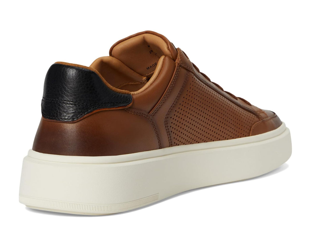 Tan leather low-top sneaker with black heel detail, perforated sides, white sole