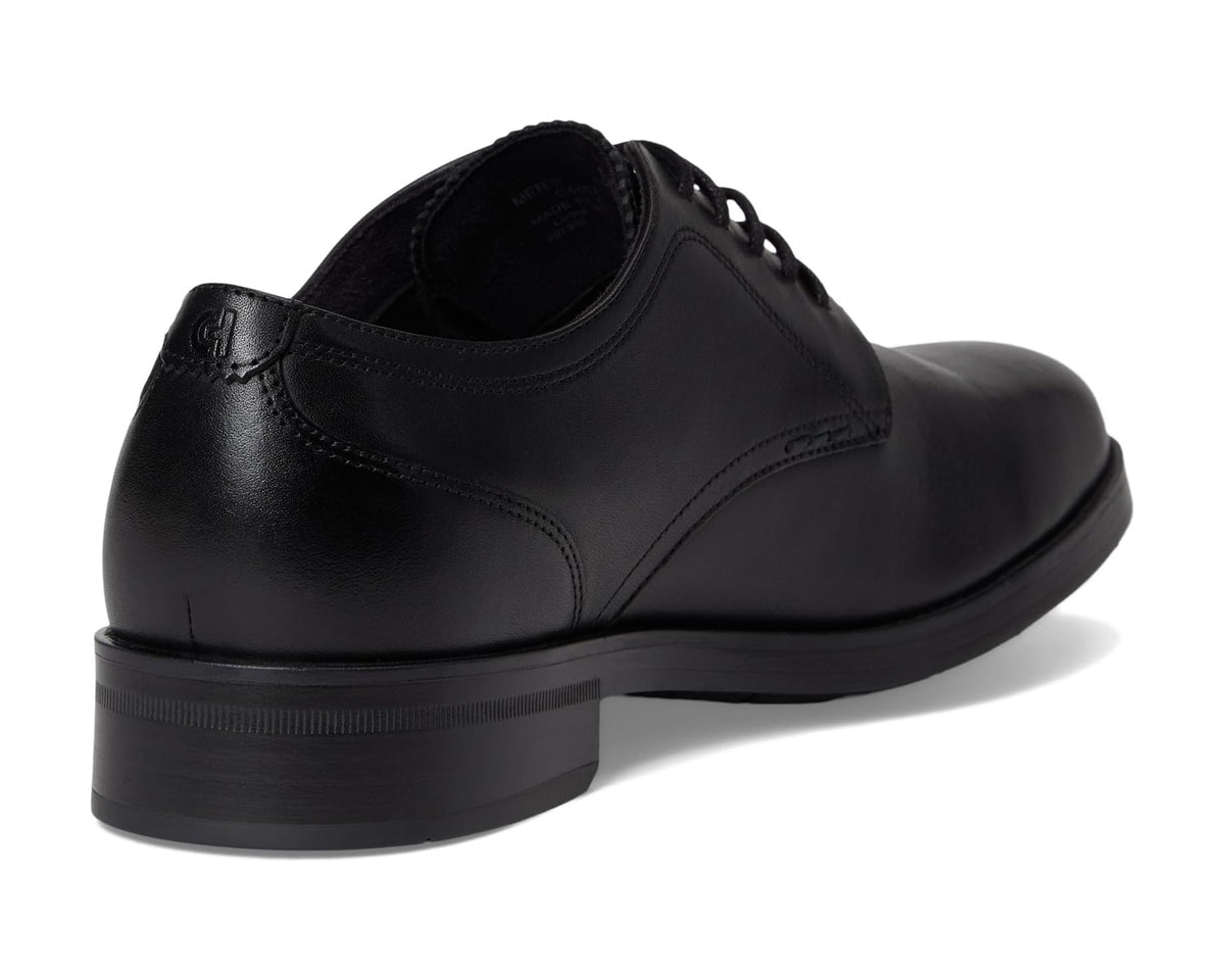 Black leather oxford shoe showing heel counter, lace-up closure, and smooth upper