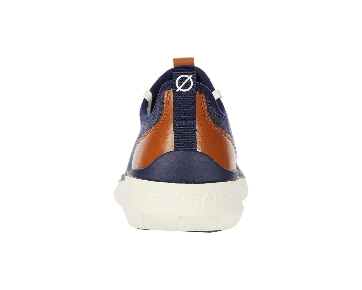 Back view of navy knit sneakers with tan leather heel accents and white midsole