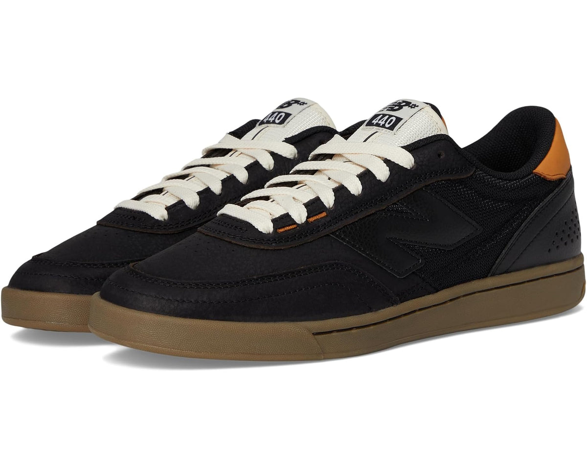 Black low-top skate sneakers with white laces and gum outsole