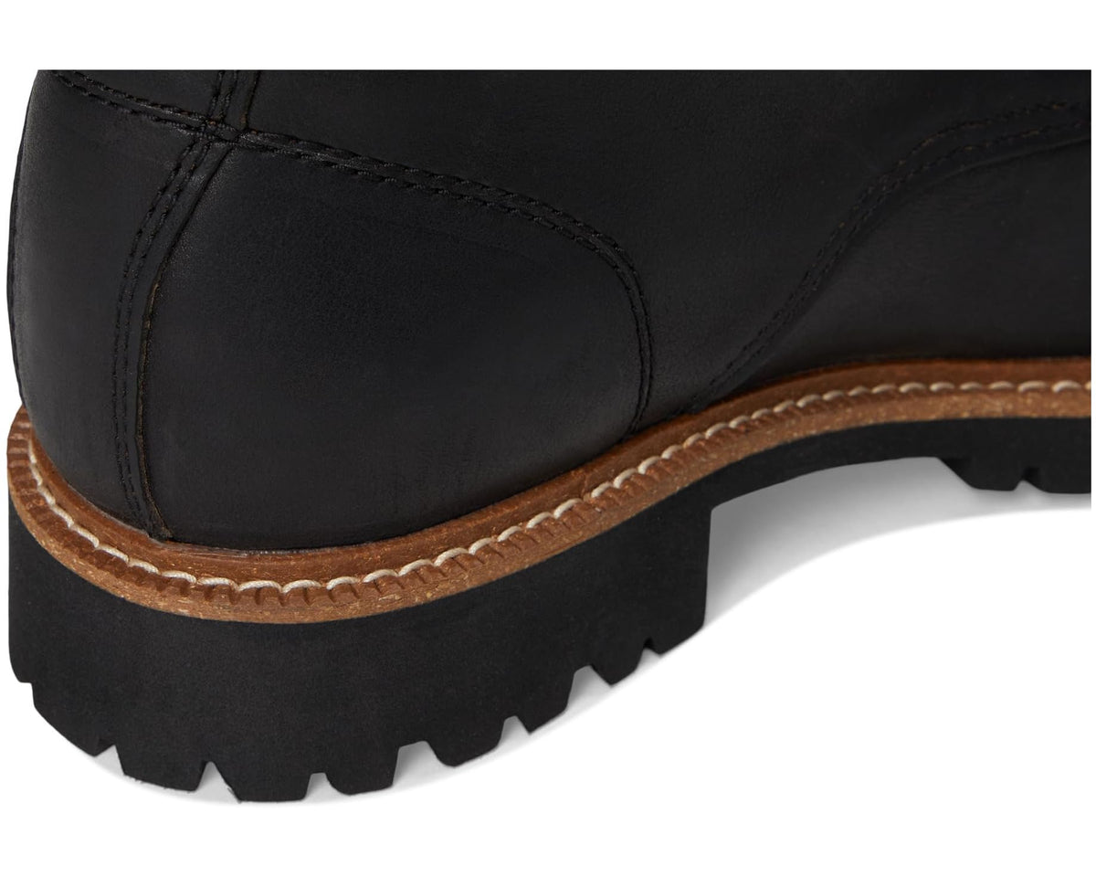 Close-up of black boot upper with brown welt stitching and textured lug sole