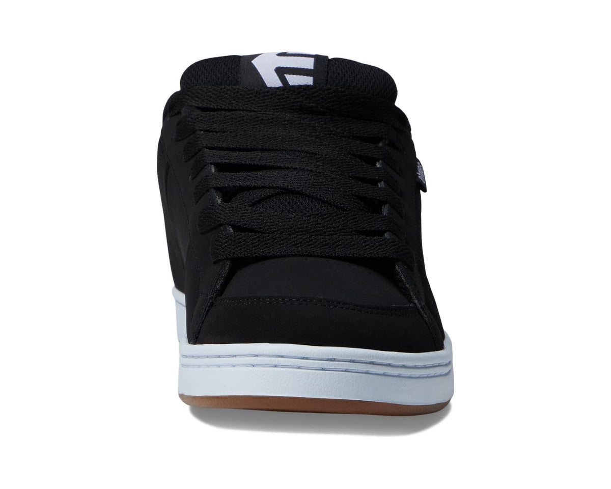 Black low-top lace-up sneaker viewed from back with white midsole and gum edge.