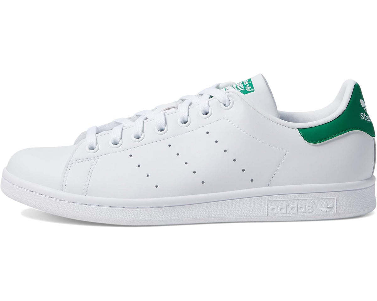 White low-top sneakers with perforated toe, green heel stripe, lace-up