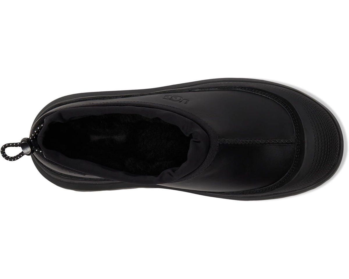 Black UGG boot showing open interior with pull-tie cord near the ankle