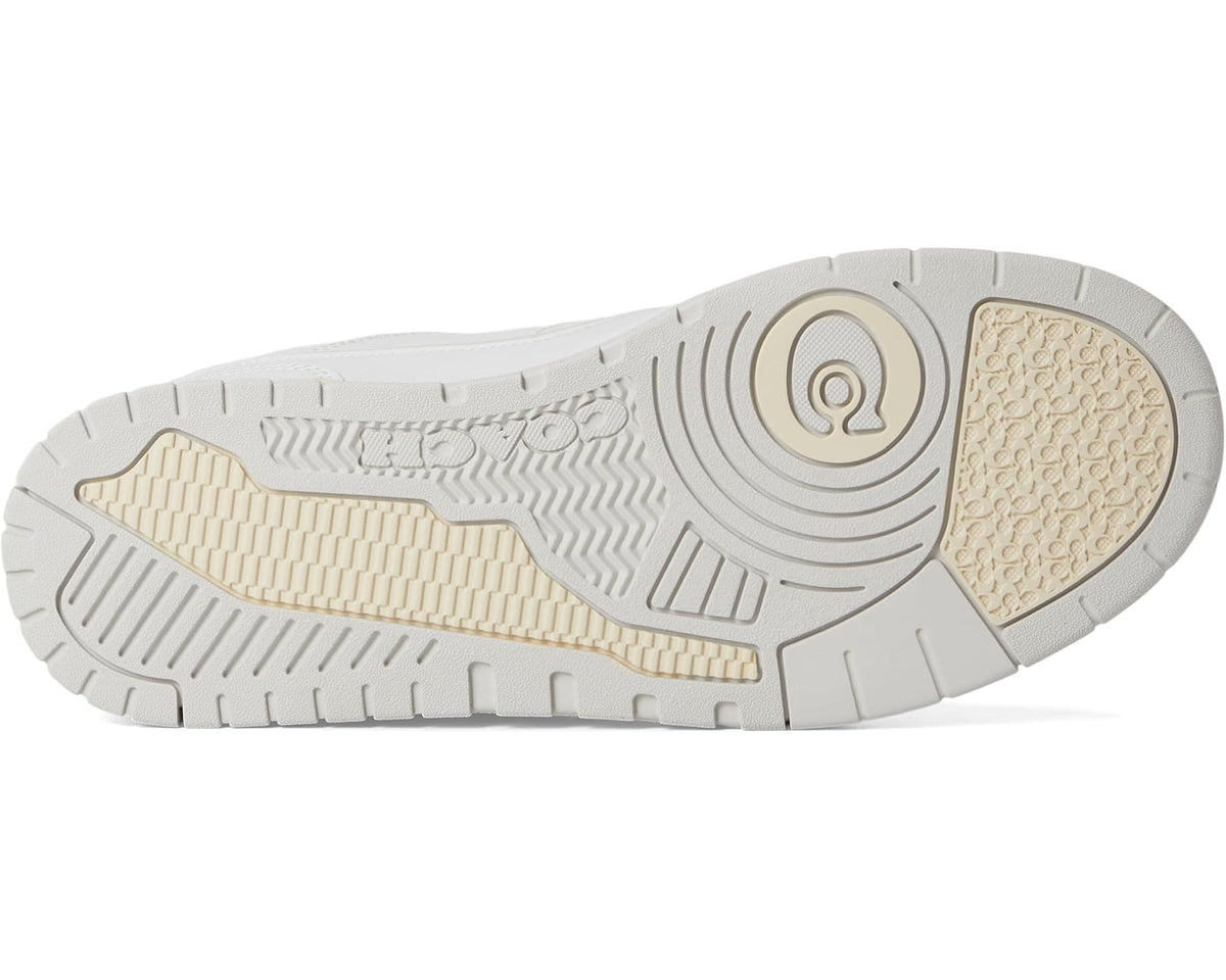 Outsole view of optic white COACH Soho sneaker with patterned tread and gum sidewall