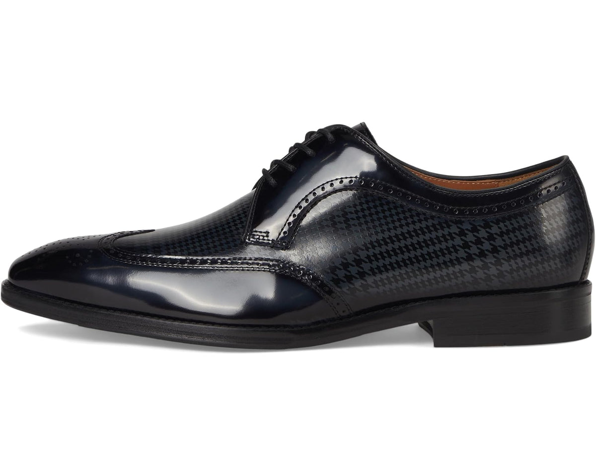 Black wingtip oxford dress shoes with lace-up closure and houndstooth paneling detail.
