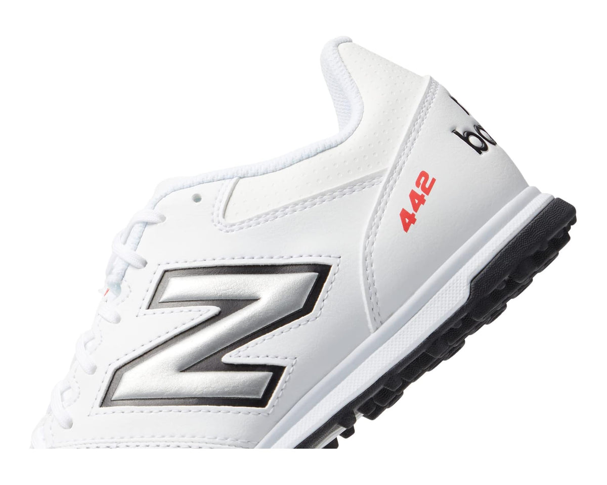 Men's white soccer cleat close-up with silver side logo and padded collar