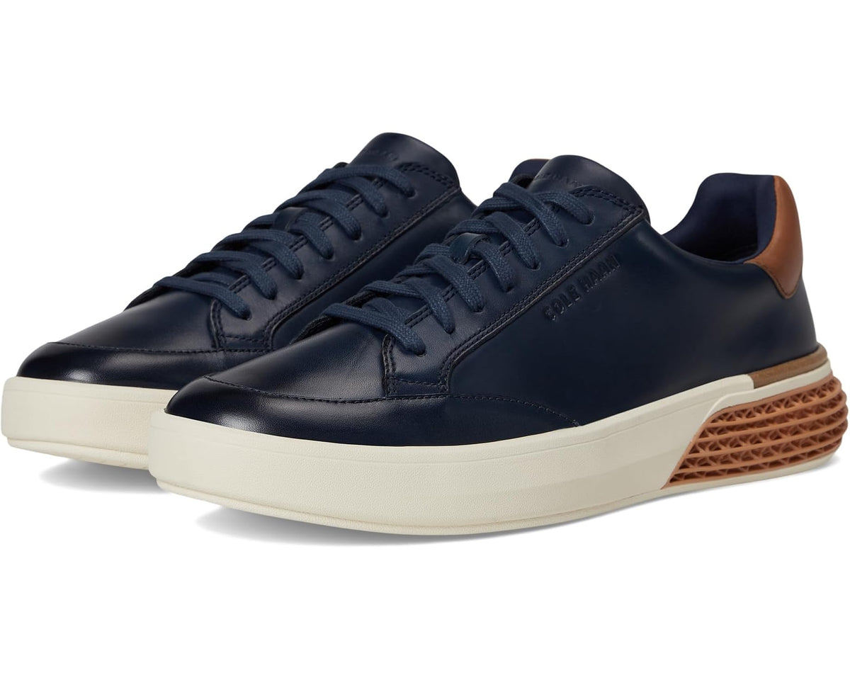 Men's navy leather low-top sneakers with tan accents, ivory sole, lace-up design.