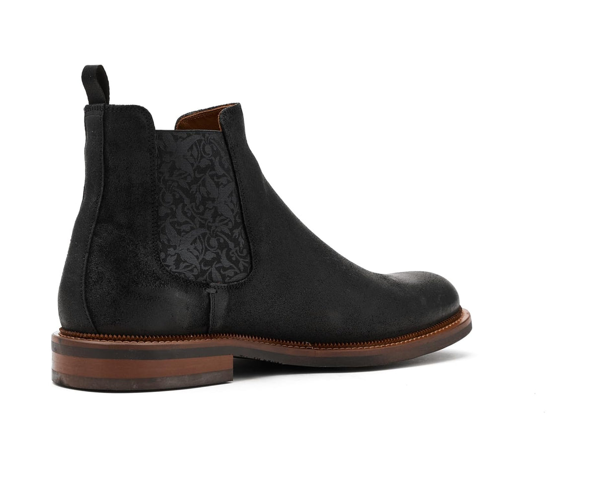 Black suede Chelsea boot with stitched welt, pull tab, and patterned elastic insert