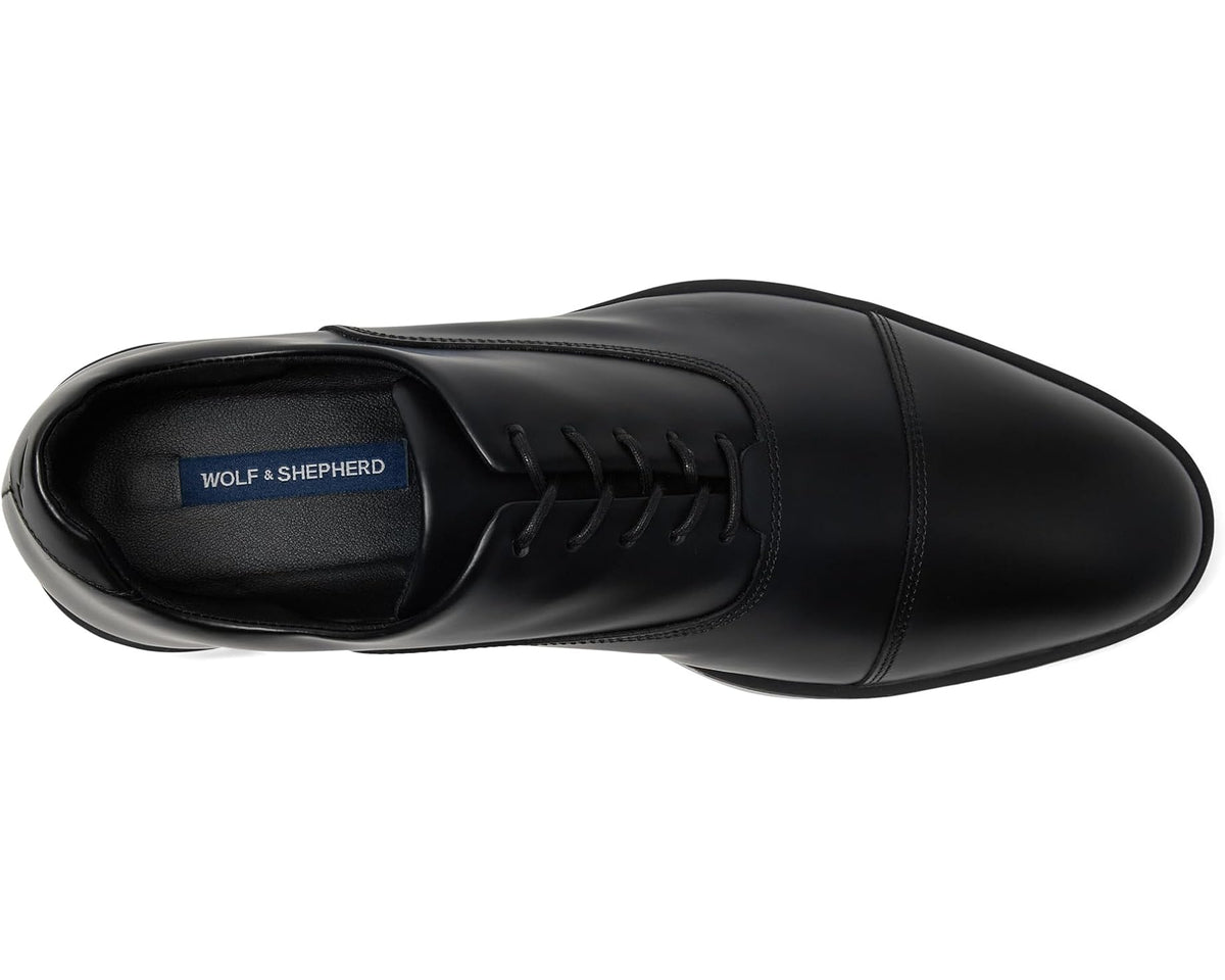 Black oxford shoes with lace-up front and blue logo label on inner tongue
