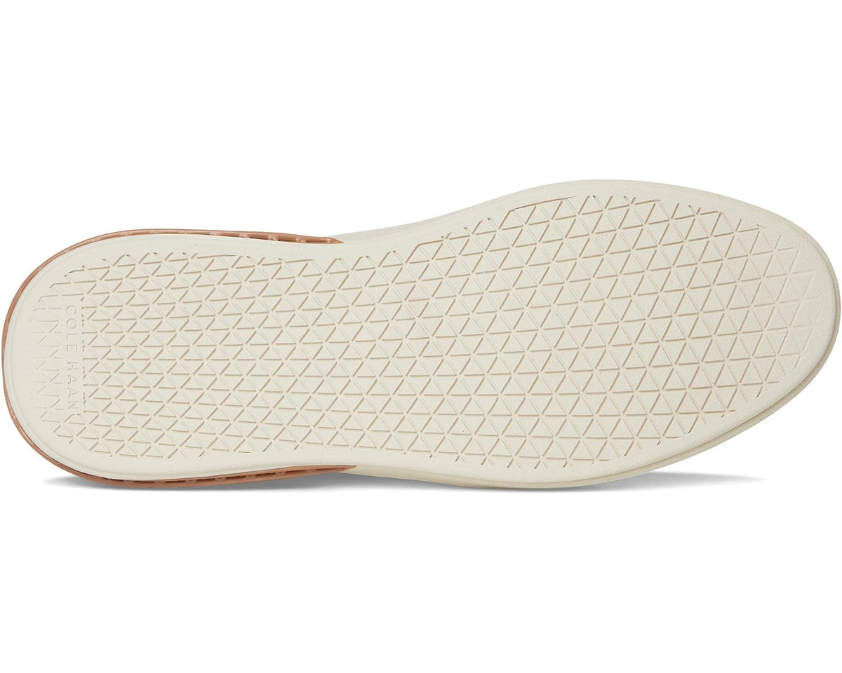 Navy low-top sneaker outsole and side, tan edge detail, textured cream sole tread.