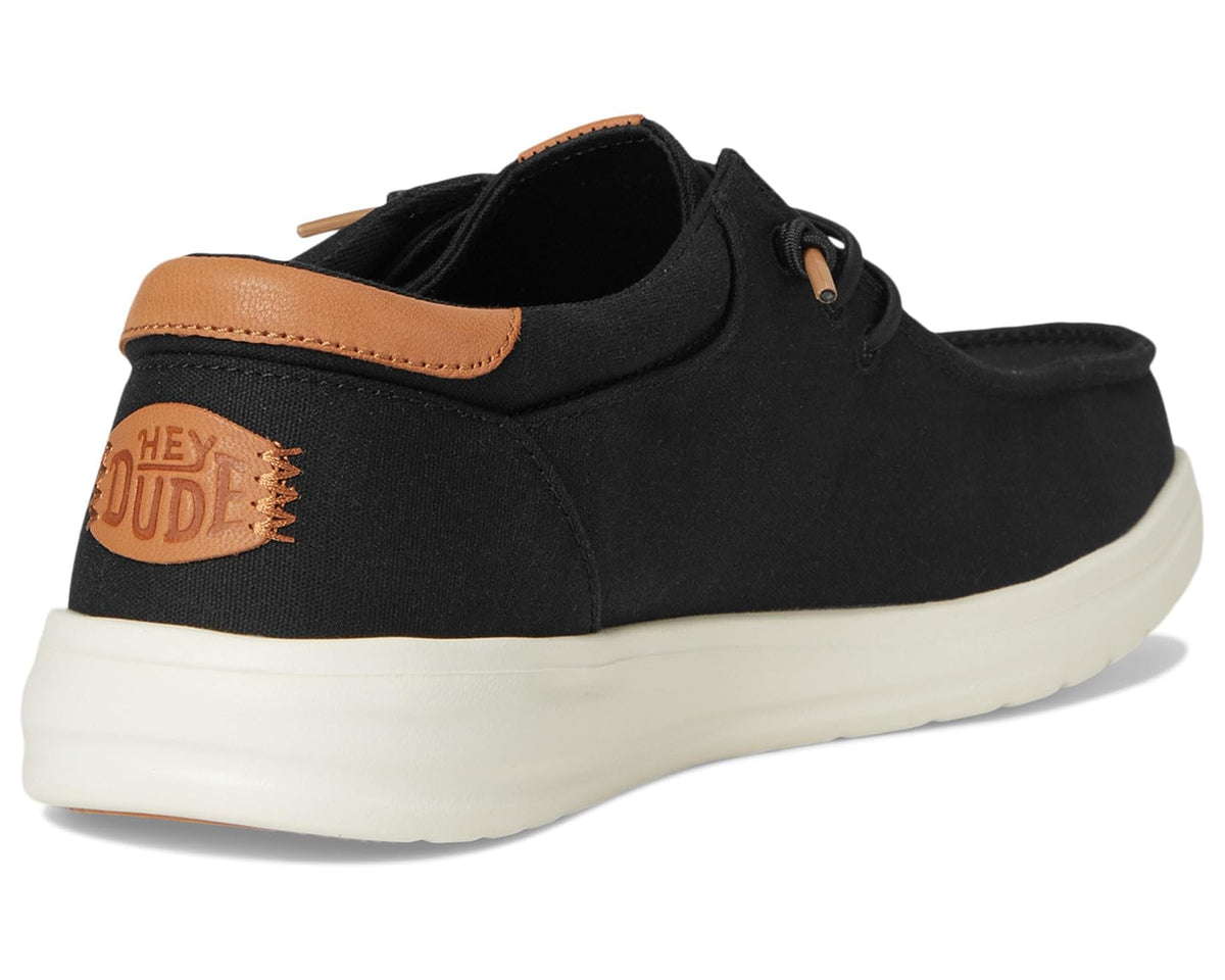 Black canvas lace-up shoe heel with tan collar trim and side “HEY DUDE” patch