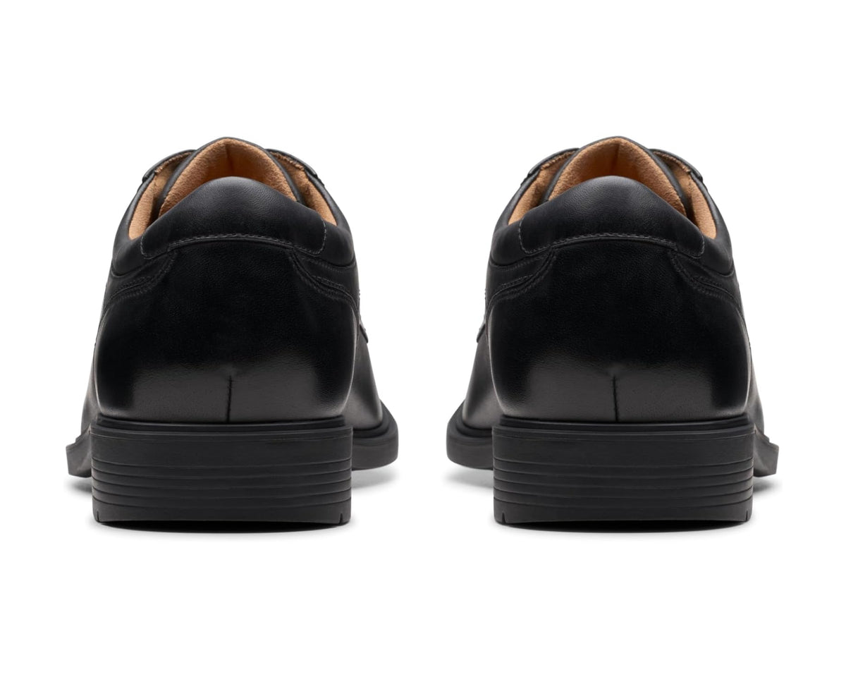 Men's black leather lace-up oxford shoes, rear view with tan lining and heel