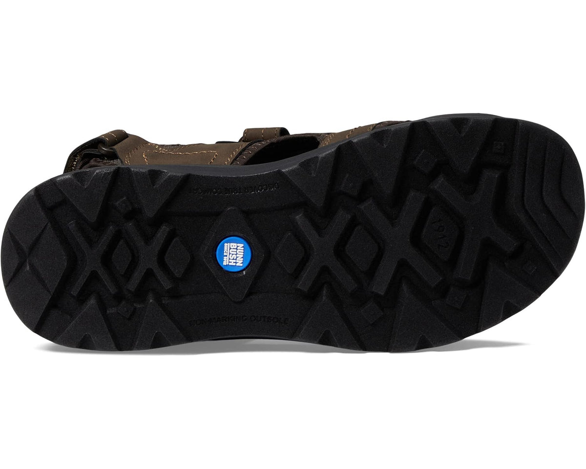 Brown closed-toe sandal outsole with textured traction tread and blue logo patch