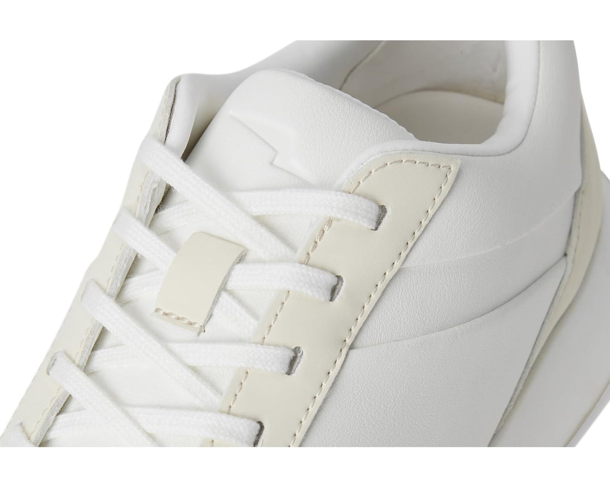 Close-up of off-white sneaker upper with laces, stitching details, and textured lining