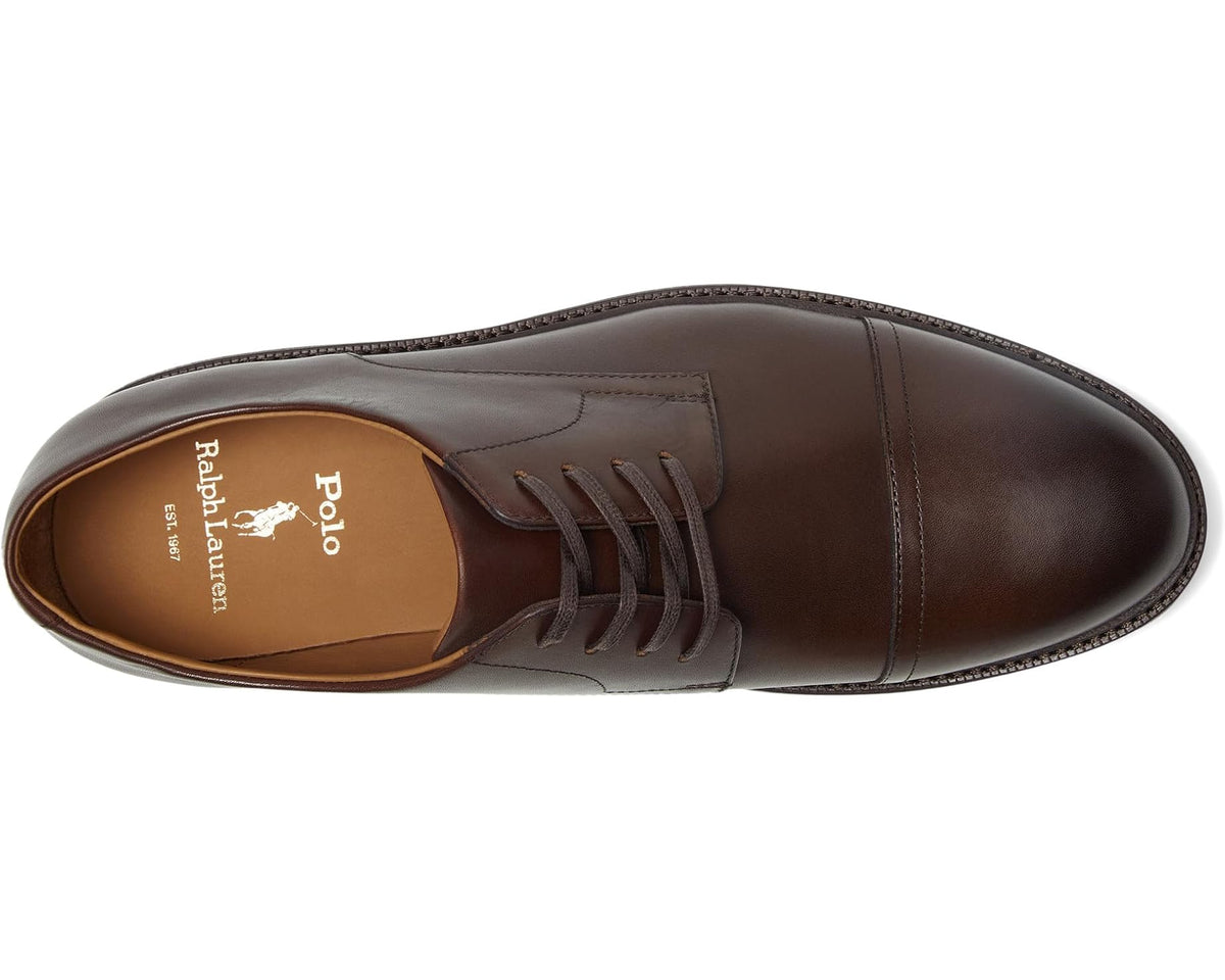 Polo Ralph Lauren logo on tan leather insole of brown lace-up cap-toe shoes.