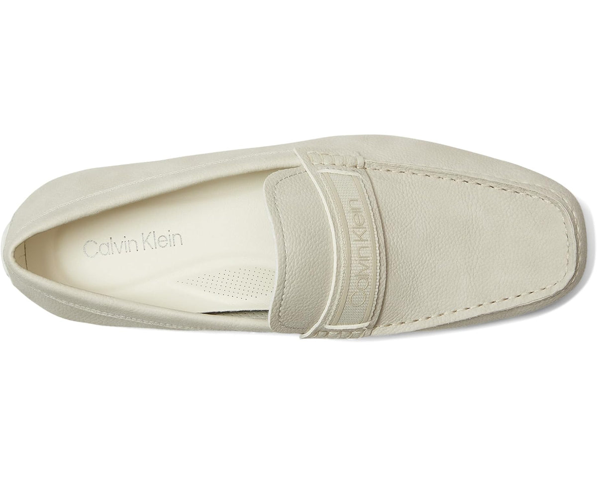 Light-colored loafer showing side logo print and moc-stitched vamp