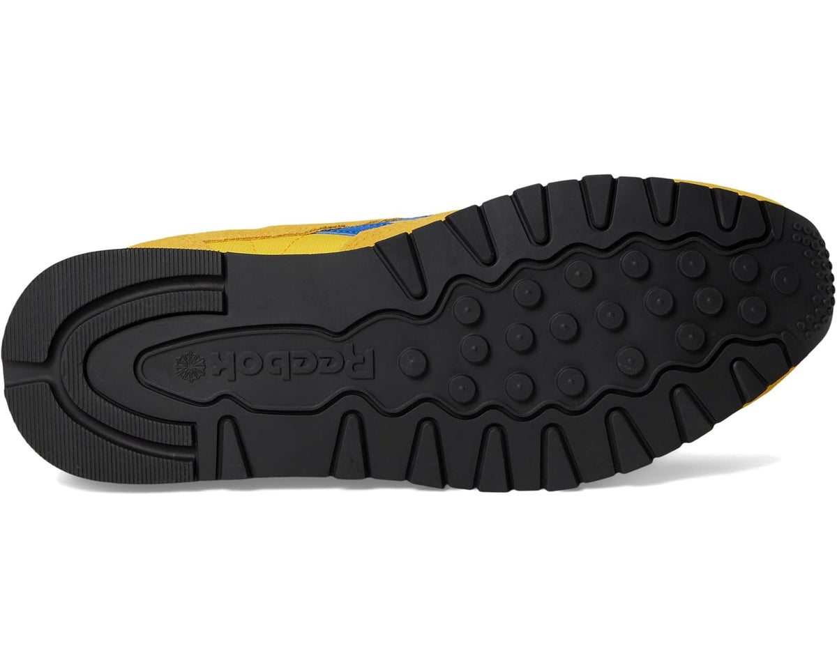 Reebok sneakers outsole with black tread and yellow upper edge.