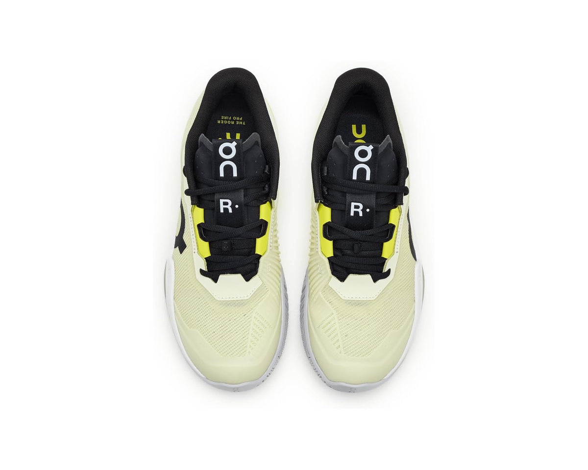 Pair of On Pro sneakers with lime trim, black laces, and light-colored uppers
