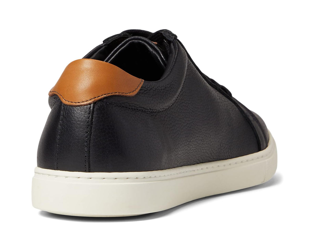 Men's black sneaker rear view with tan-trim collar and white rubber sole