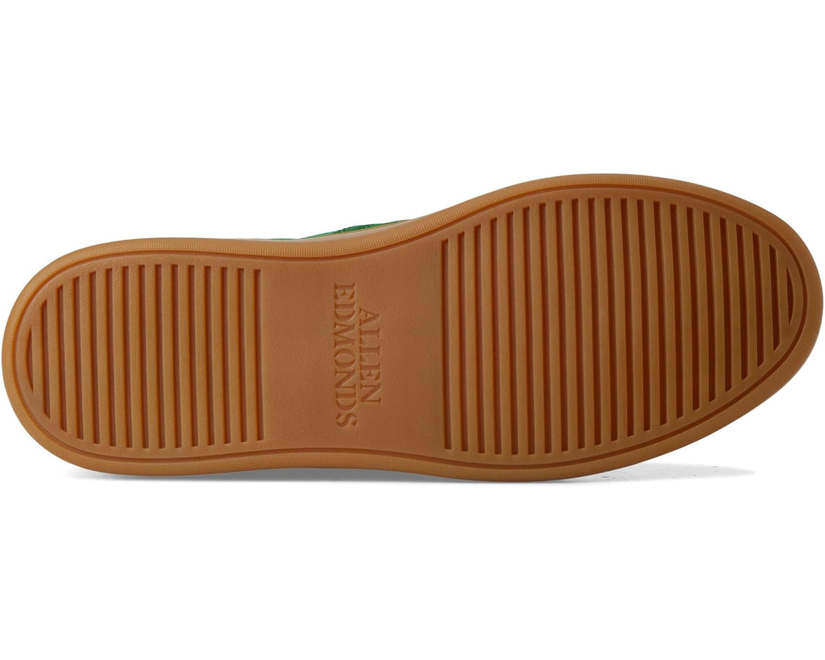 Tan rubber outsole with vertical tread and embossed brand mark.