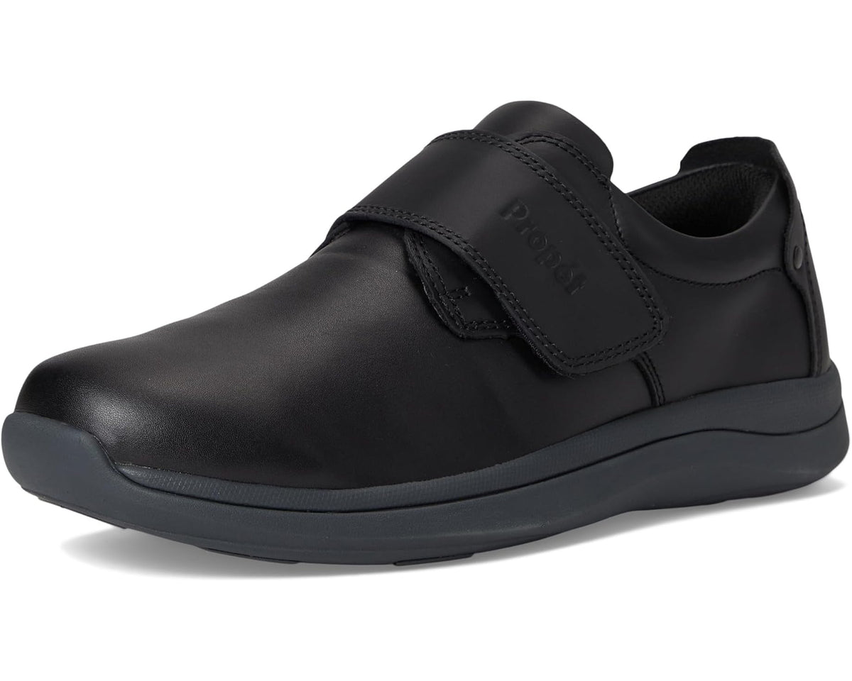 Men's black Propet slip-on shoe with strap closure and curved rubber sole