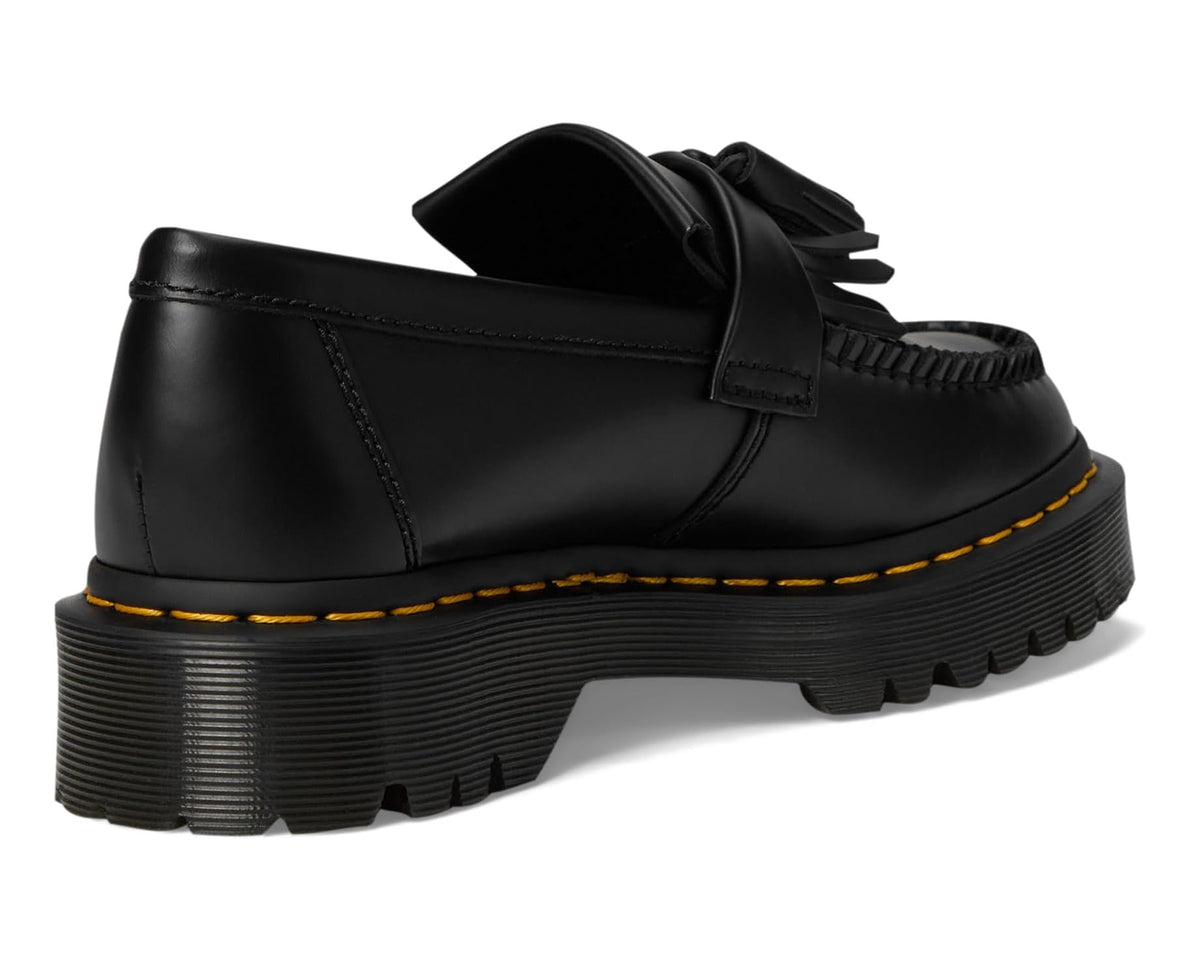 Black leather loafer with heel tab, tassel fringe, and yellow welt stitching