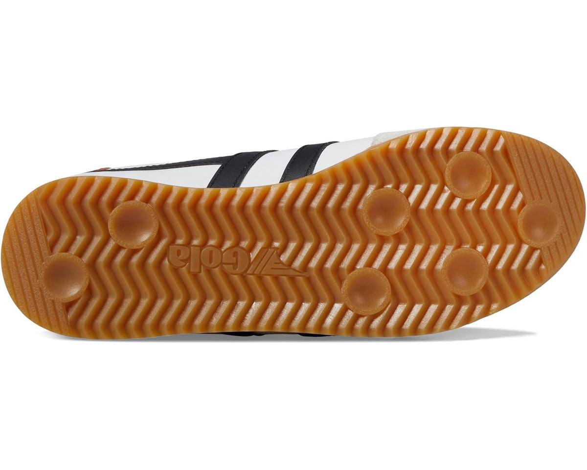 Rubber outsole of white and black leather sneakers with orange-brown traction pattern