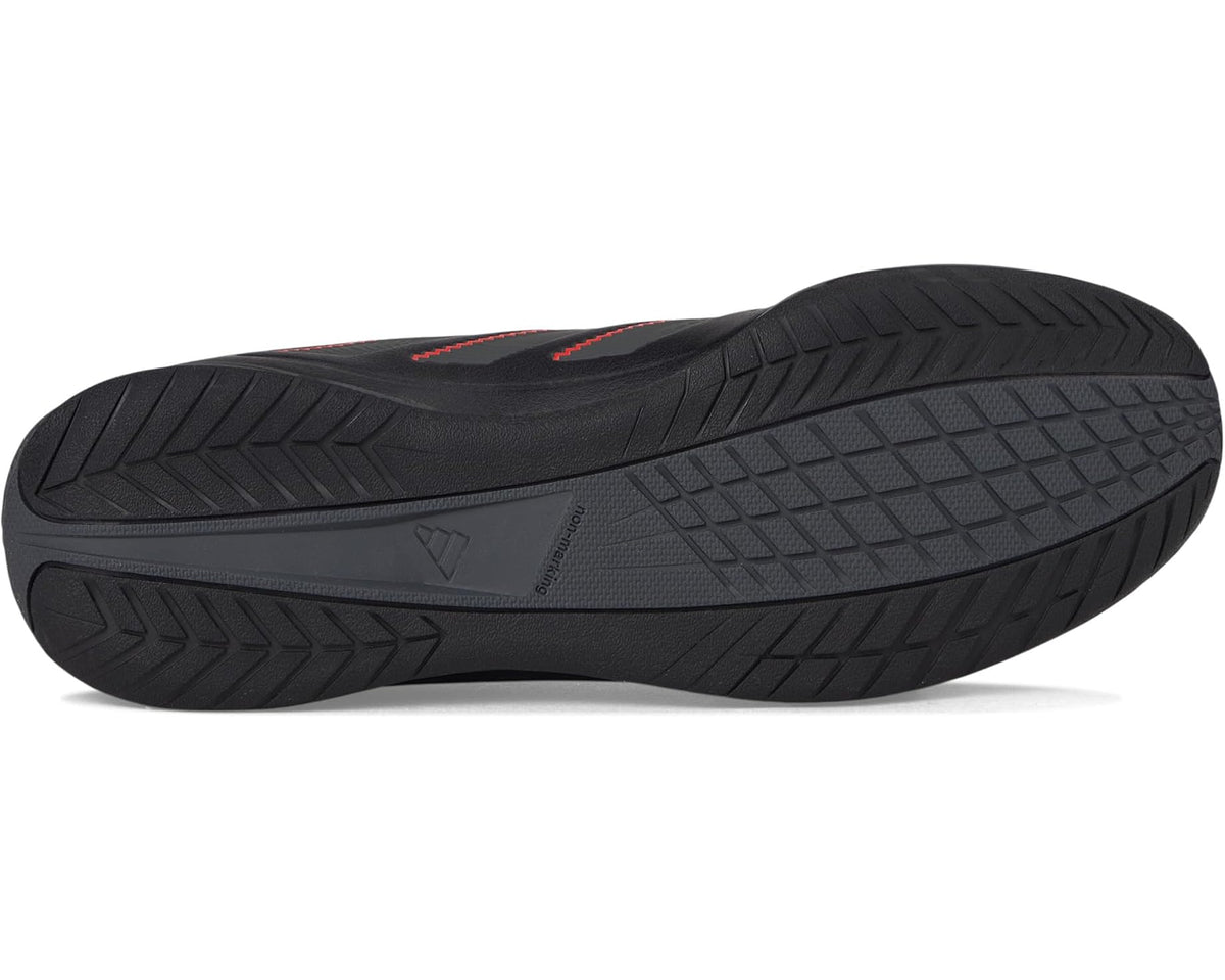 Black adidas indoor soccer shoes, textured rubber outsole tread with red accents