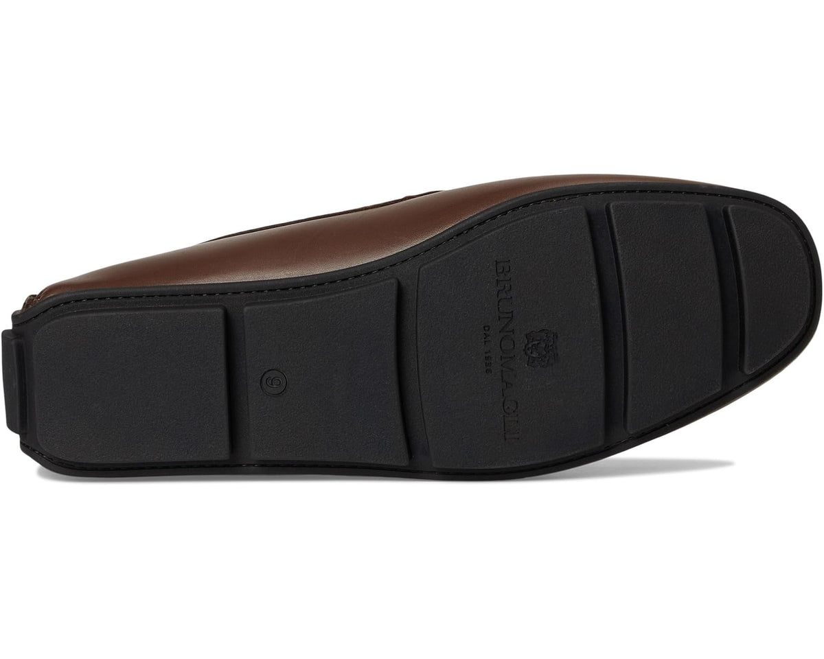 Brown leather loafer outsole view with tread and side logo stamp