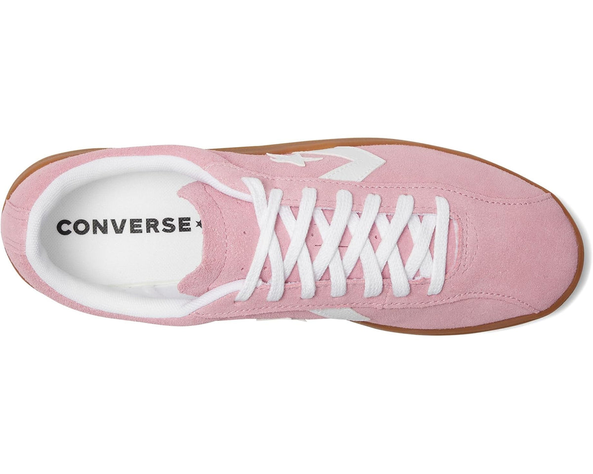 Pink suede low-top sneaker with white laces, Converse logo inside, and gum sole