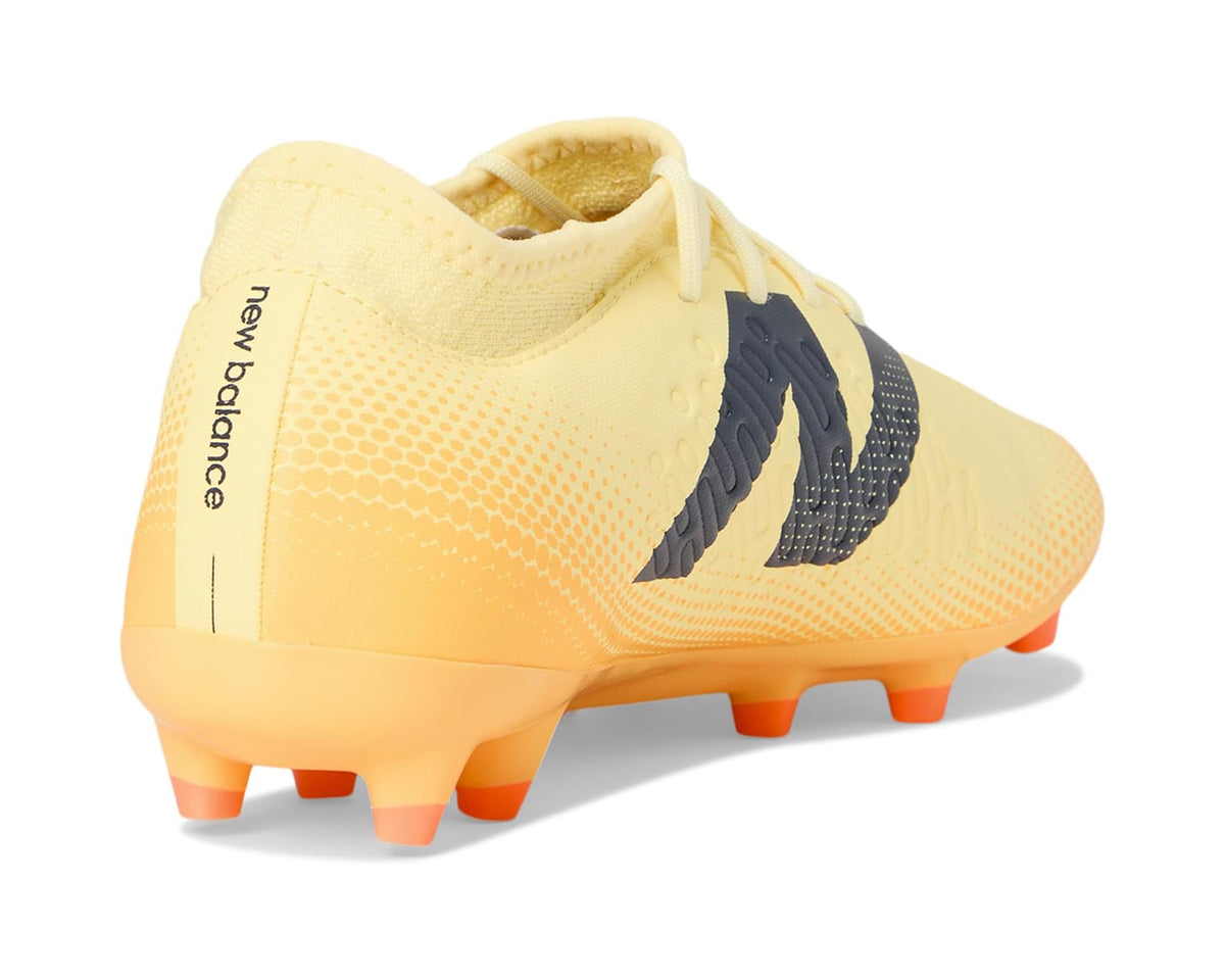Light yellow soccer cleats with New Balance logo on heel and orange FG studs