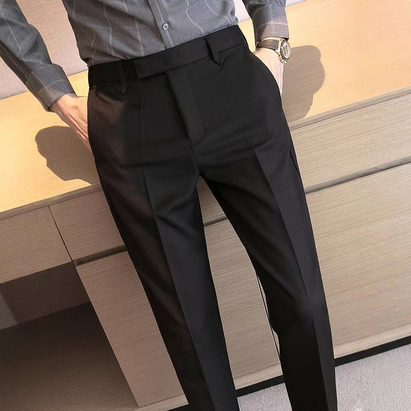 Men's dress pants in black, pleated front with belt loops and tapered leg fit