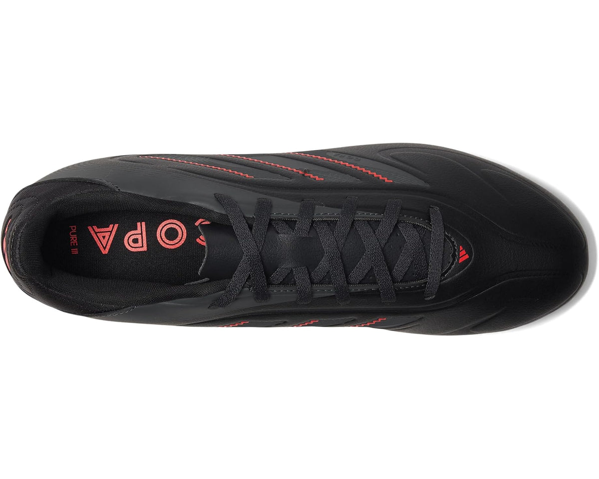 Black soccer cleats with lace-up closure and red lining on the inside of the tongue