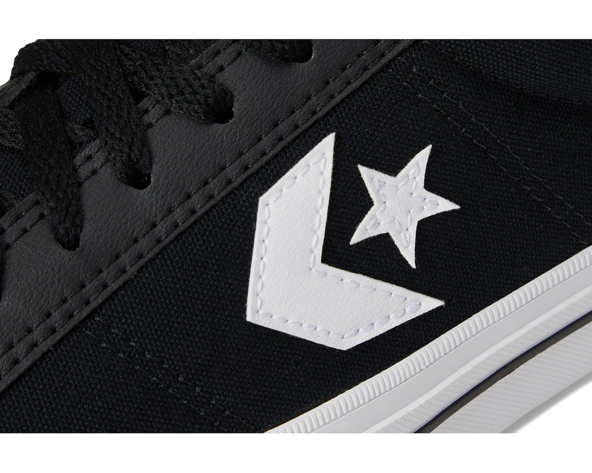 Close-up of black Converse sneaker with white star emblem and textured rubber toe cap