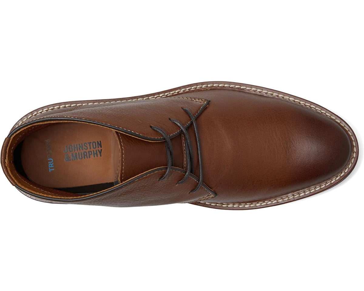 Tan lace-up chukka boots with stitched toe and side panels, leather upper.