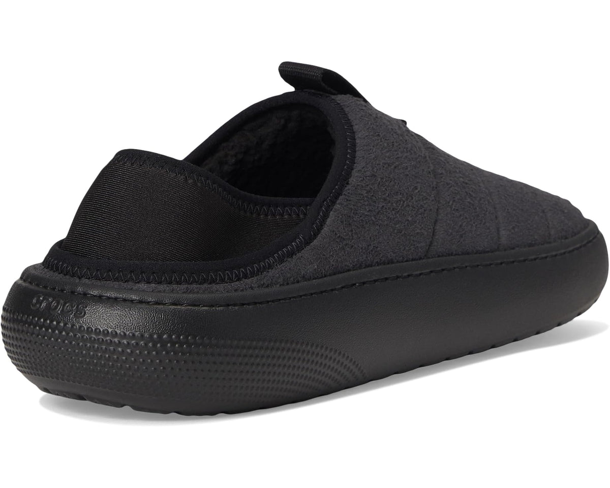Black suede slip-on clog showing knit lining and cushioned heel