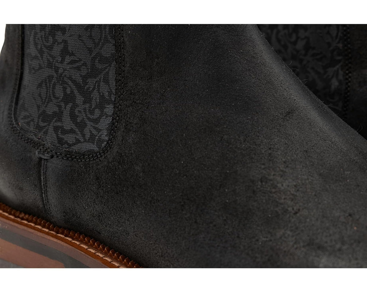 Close-up of black suede Chelsea boot with patterned elastic insert and stitched edge