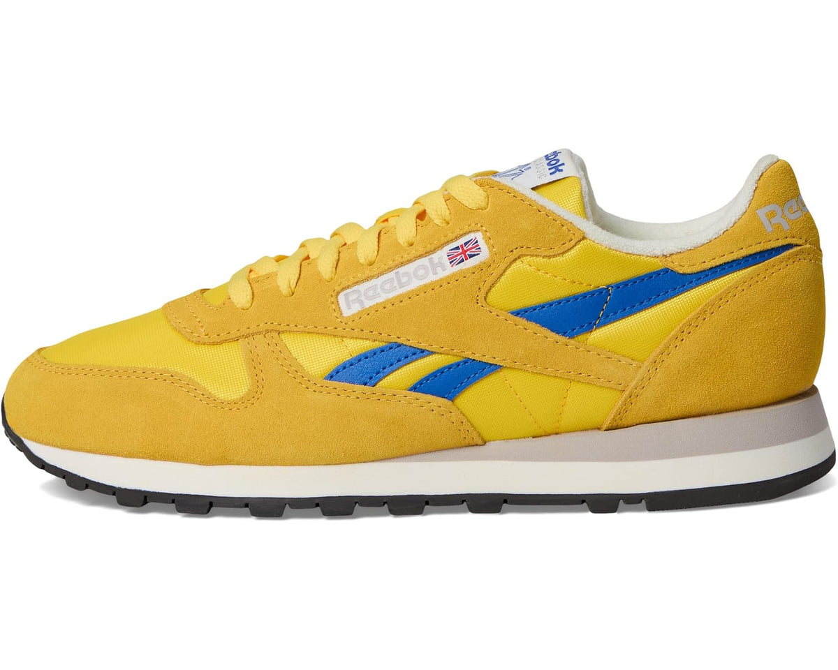 Reebok leather sneakers, yellow with blue cross strap and white heel collar.