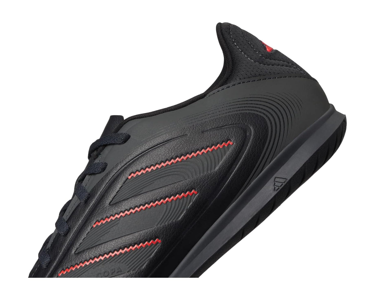 Black adidas indoor soccer shoe, close-up of red stripe graphics and lace area
