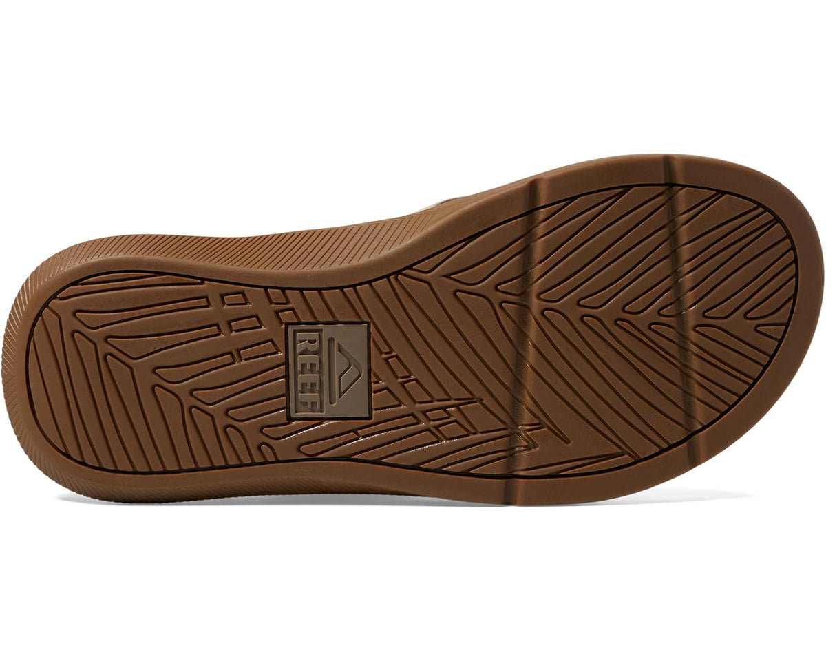 Tan rubber sandal outsole with patterned tread and center logo