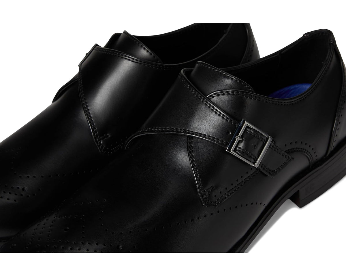 Black leather monk strap close-up with metal buckle and stitched panels