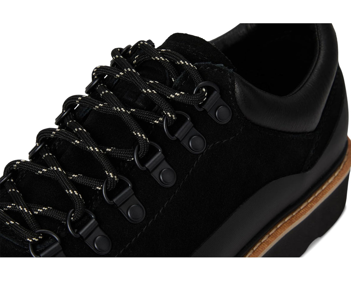 Men's black lace-up shoes close-up with metal eyelets and braided black laces
