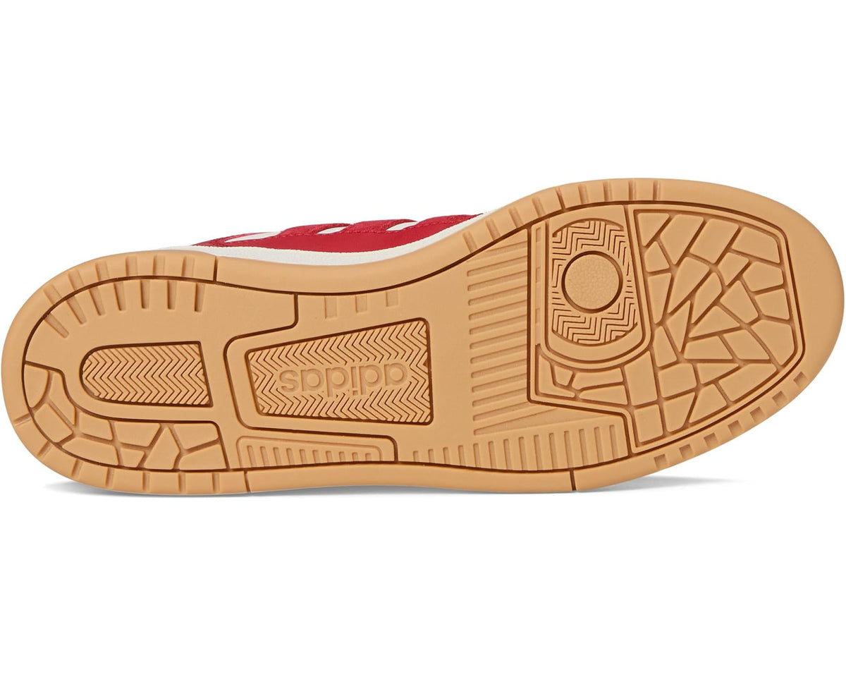 Gum brown rubber outsole with traction tread on red adidas low-top sneakers.