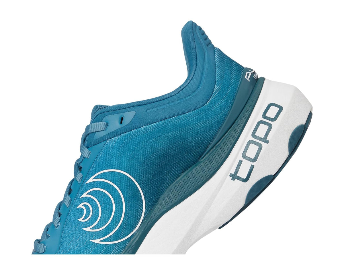 Side view of blue running shoe showing lace details and white TOPO branding