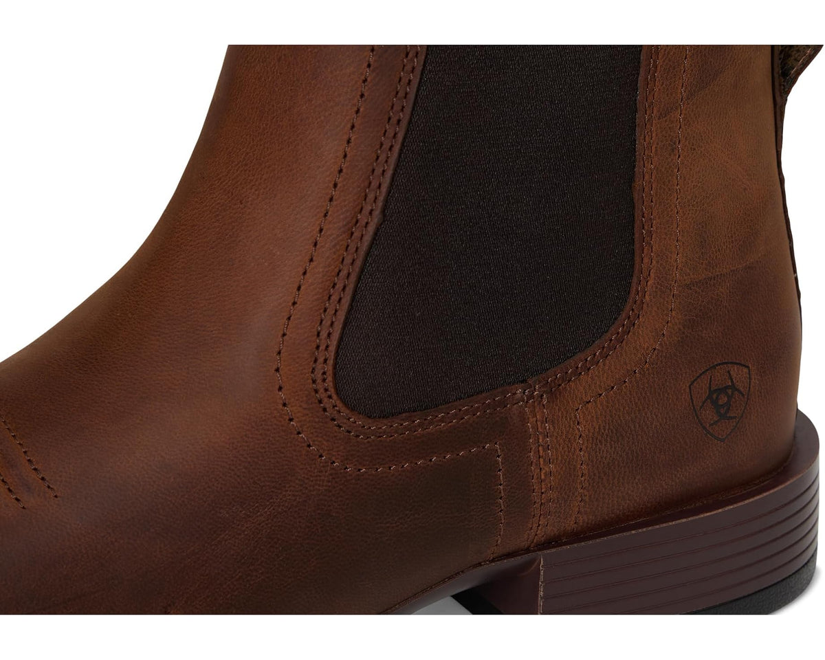 Close-up of rough tan boot upper with black elastic panel and stitched detailing