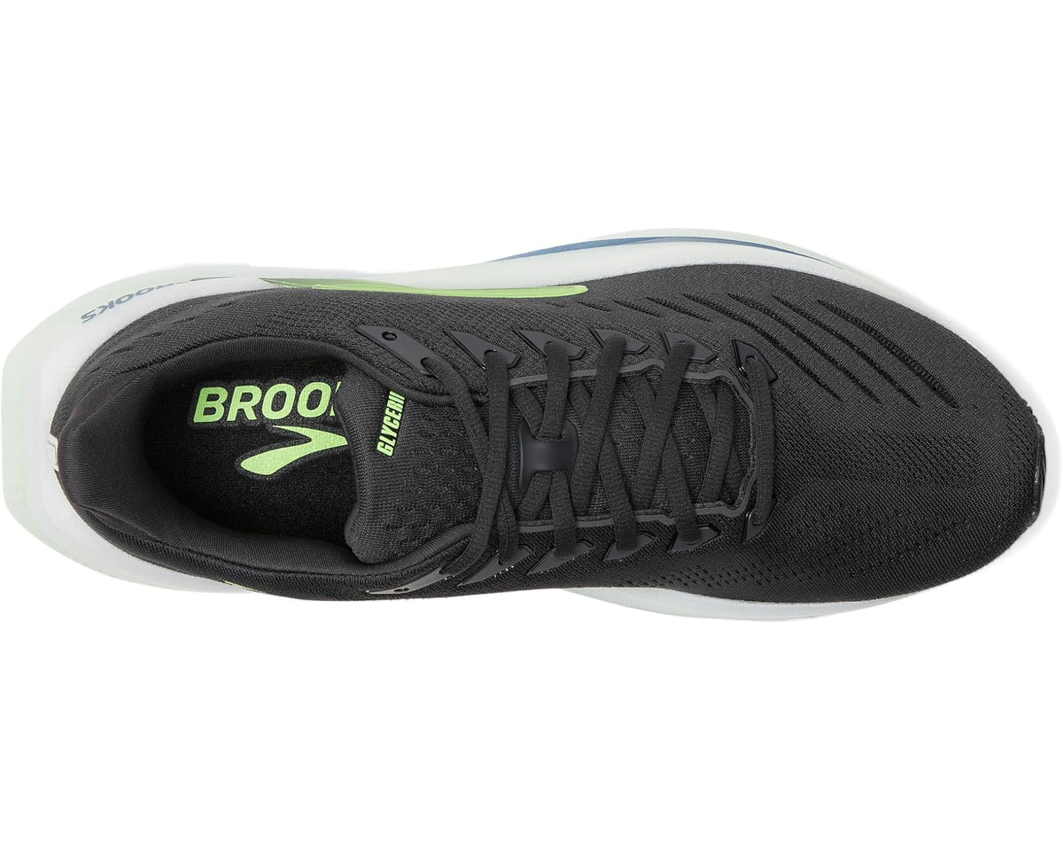 Running shoe side view: black upper, green logo, white sole edge