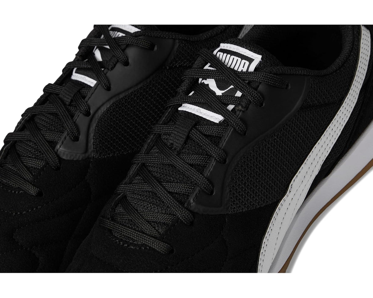 Close-up of men's indoor soccer trainer shoes: black mesh laces and white Puma formstripe