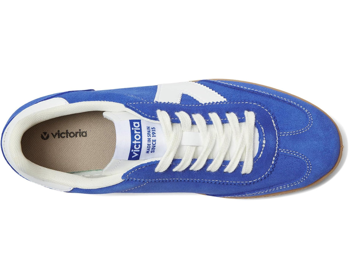 Royal blue suede sneakers, side view with white lace eyelets and brand logo