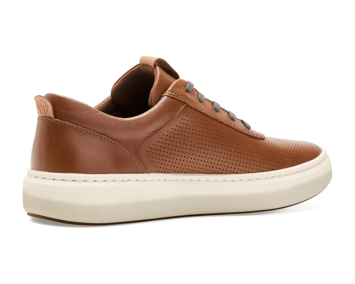 Tan leather low-top sneakers with perforated panels, gray laces, and cream rubber sole
